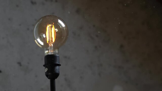 Modern WiFI connected light bulb switching from warm to cold color and reversed with a concrete background