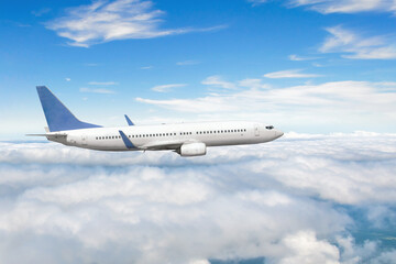 Naklejka na ściany i meble Side view of a flying passenger plane on clouds