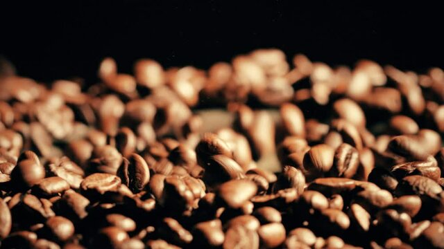 Slow motion shot of bouncing coffee beans on a loudspeaker
