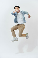 Young Asian man jumping in the air on white background.
