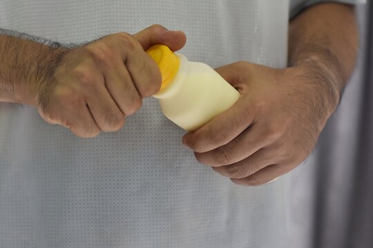 An Asian Man Opens A Bottle Of Milk By Hand.