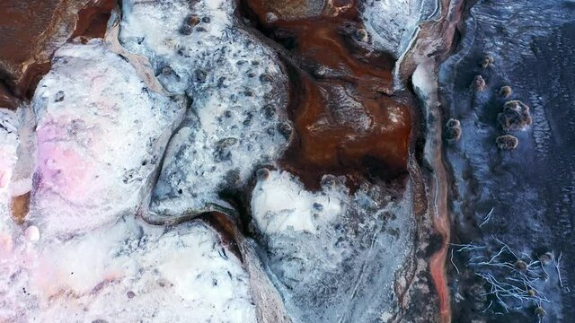 Aerial over rugged desert terrain with mars like textures and variety of colors