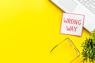 Wrong way icon on office desk - yellow, top view copy space