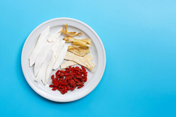 Mixed chinese herb on plate on blue background.