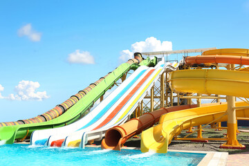 Different colorful slides in water park on sunny day