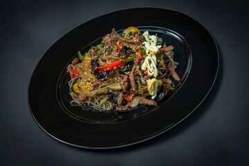 Korean fried sweet potato noodles fried with vegetables and wood mushrooms