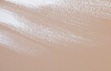 texture of beige background lightly splattered with white paint splashes