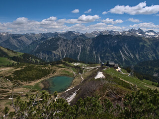Obraz premium Beautiful panorama view from the top of alpine Fellhorn peak (2,037 m) near Oberstdorf, Allgäu, Bavaria, Germany with mountain station of Fellhornbahn and turquoise shimmering Schlappolt Lake.
