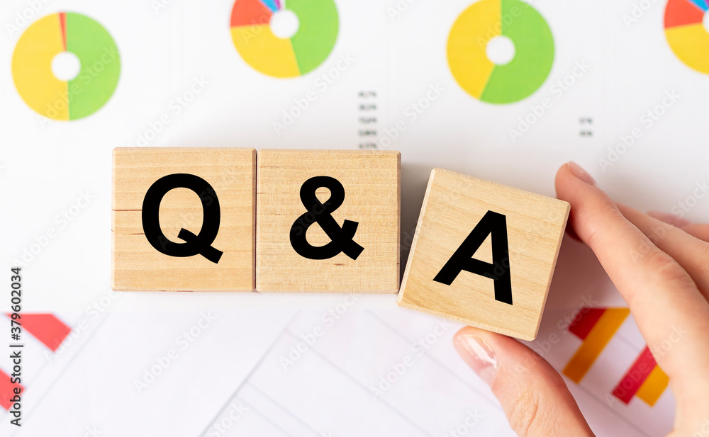 Poster q and a - questions and answers text on wooden cube blocks in female hand holding the dice with a le