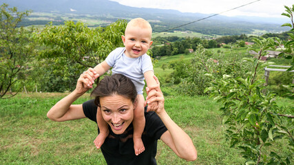 A cute mother and her adorable baby boy at a vineyard. A day in nature