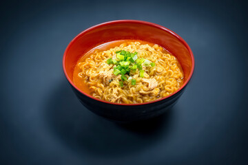 Korean Ramyeon Soup In a Red And Black Bowl With Minced Spring Onion 