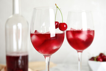 Delicious cherry wine with ripe juicy berries on light background, closeup