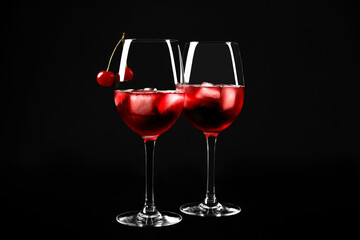 Delicious cherry wine with ripe juicy berries on black background