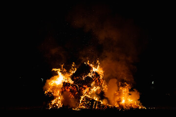 Hot red burning large fire with the black starry night sky.
