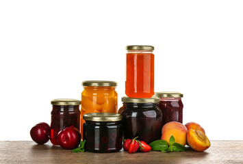Jars of pickled fruits and jams on grey table