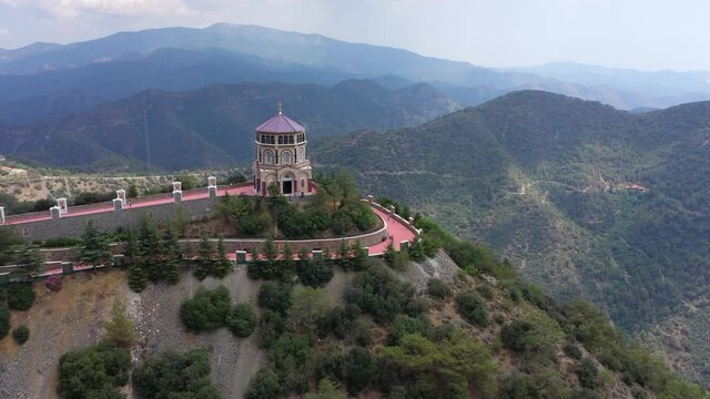 Chapel on top of a mountain. Monastery in Mountains. Forest at the top of the mountain. The drone flies over the mountains. Tourists at the top of the mountain. Cross on top of the mountain