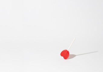Fototapeta na wymiar red heart shaped lollipop on white background
