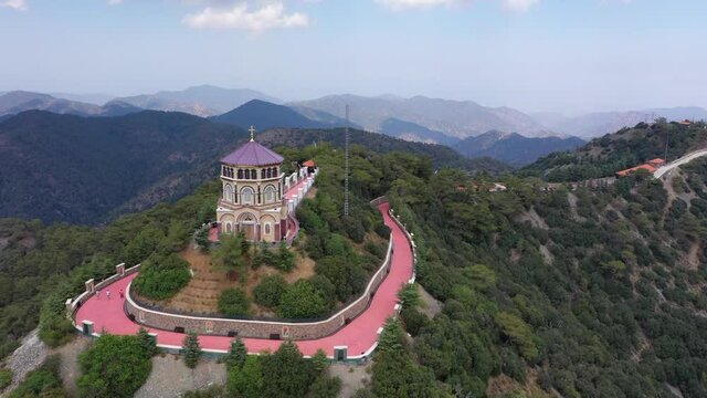 Chapel on top of a mountain. Monastery in Mountains. Forest at the top of the mountain. The drone flies over the mountains. Tourists at the top of the mountain. Cross on top of the mountain