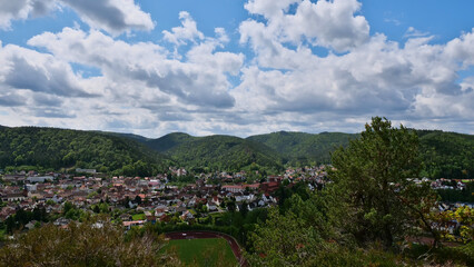 Fototapeta na wymiar Panorama view over village Dahn (Palatinate Forest, Rhineland-Palatinate, Germany), located in a valley surrounded by forests and hills with sandstone formation in background at sunny spring day.