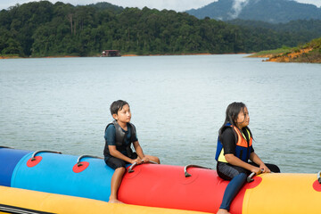 People enjoying water activities on banana boat at the Kenyir Lake, Terengganu, Malaysia.