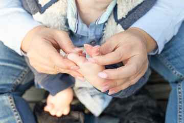 a mother holds the hand of her disabled child with cerebral palsy. support for parents. Disability.