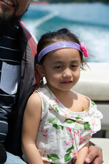 Happy toddler on a boat with family. Vacation, travel and active kid concept.