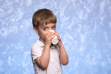 little boy drinks water from a disposable cup of cornstarch. ecologicaly clean. replacing plastic...