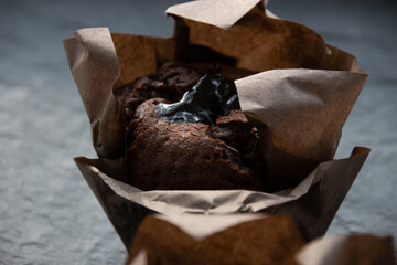 Photo A chocolate muffin on a dark stone board. Delicious pastries