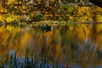beautiful autumn landscape yellow trees reflected in the water of the lake fishermen catching fish