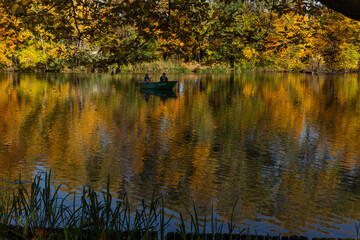 beautiful autumn landscape yellow trees reflected in the water of the lake fishermen catching fish