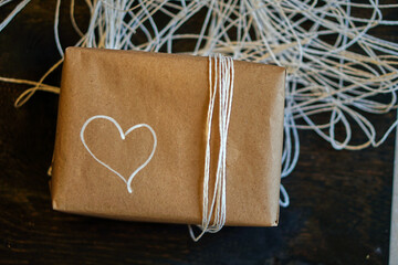 Gift box with minimalist style wrapping design. White heart drawing on the packaging box. The...