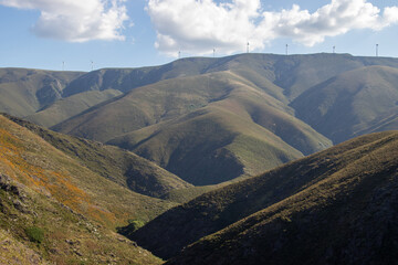 Beautiful mountain landscape with a wind farm placed on top of the mountain, with fantastic blue...