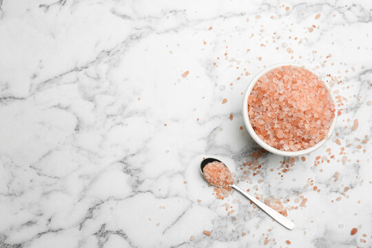 Spoon and bowl with pink himalayan salt on white marble table, flat lay. Space for text - Powered by Adobe