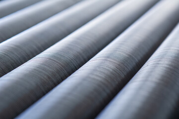 Stainless steel tubes with cooling ribs. Industrialabstract with very shallow depth of field.