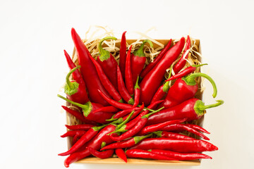 red bitter chili peppers in a craft box on a white blank background for text