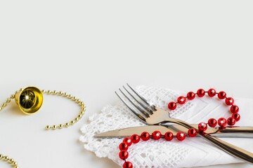 Elegant Cutlery Set,on stylish white color fabric napkin on white surface with bell chain and copy space