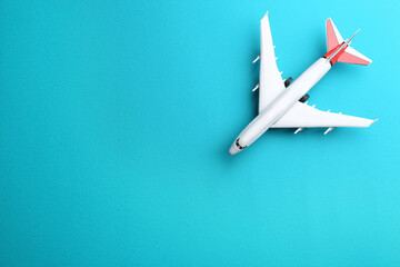 Toy airplane on light blue background, top view. Space for text