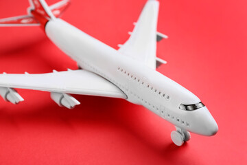 Toy airplane on red background, closeup view
