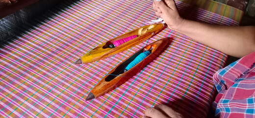 Image of two handloom shuttles on a fabric from the state of Tripura, India.