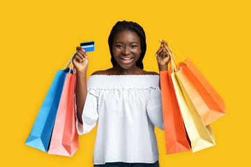Fototapeta na wymiar Big Shopping. Joyful Black Woman Posing With Shopper Bags And Credit Card