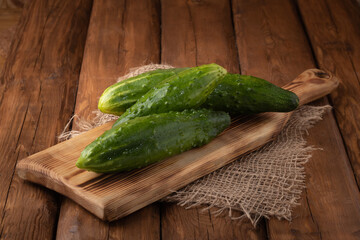 Eco vegetables - fresh green cucumber on wooden background, vegan food