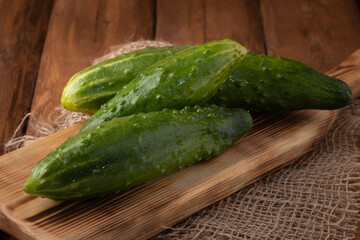 Eco vegetables - fresh green cucumber on wooden background, vegan food