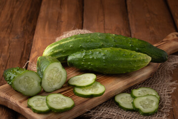 Eco vegetables - fresh green cucumber on wooden background, vegan food