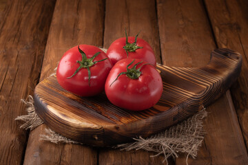 Eco vegetables - fresh red tomato on wooden background, vegan food