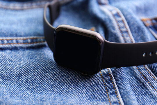 Modern stylish smart watch on jeans, closeup