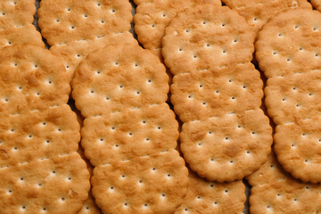 Many delicious crackers as background, top view