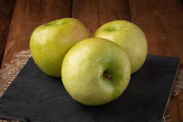 Eco fruits - fresh green apples on wooden background, vegan food