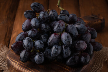 Eco fruits - fresh dark grapes on wooden background, vegan food