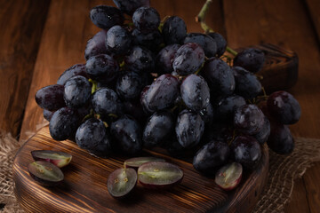 Eco fruits - fresh dark grapes on wooden background, vegan food