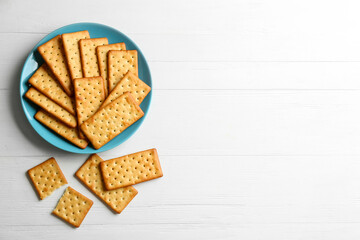 Delicious crackers on white wooden table, flat lay. Space for text